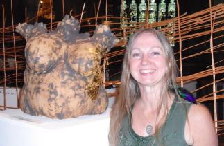 Dawn Wesselby in front of one of her sculptures of a female torso