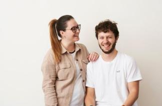 In the middle of the picture in front of white background is smiling Rachel and founder of Studio 74 Dariusz 