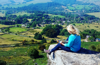 Kelly Herrick sketching sat at Curbar Edge